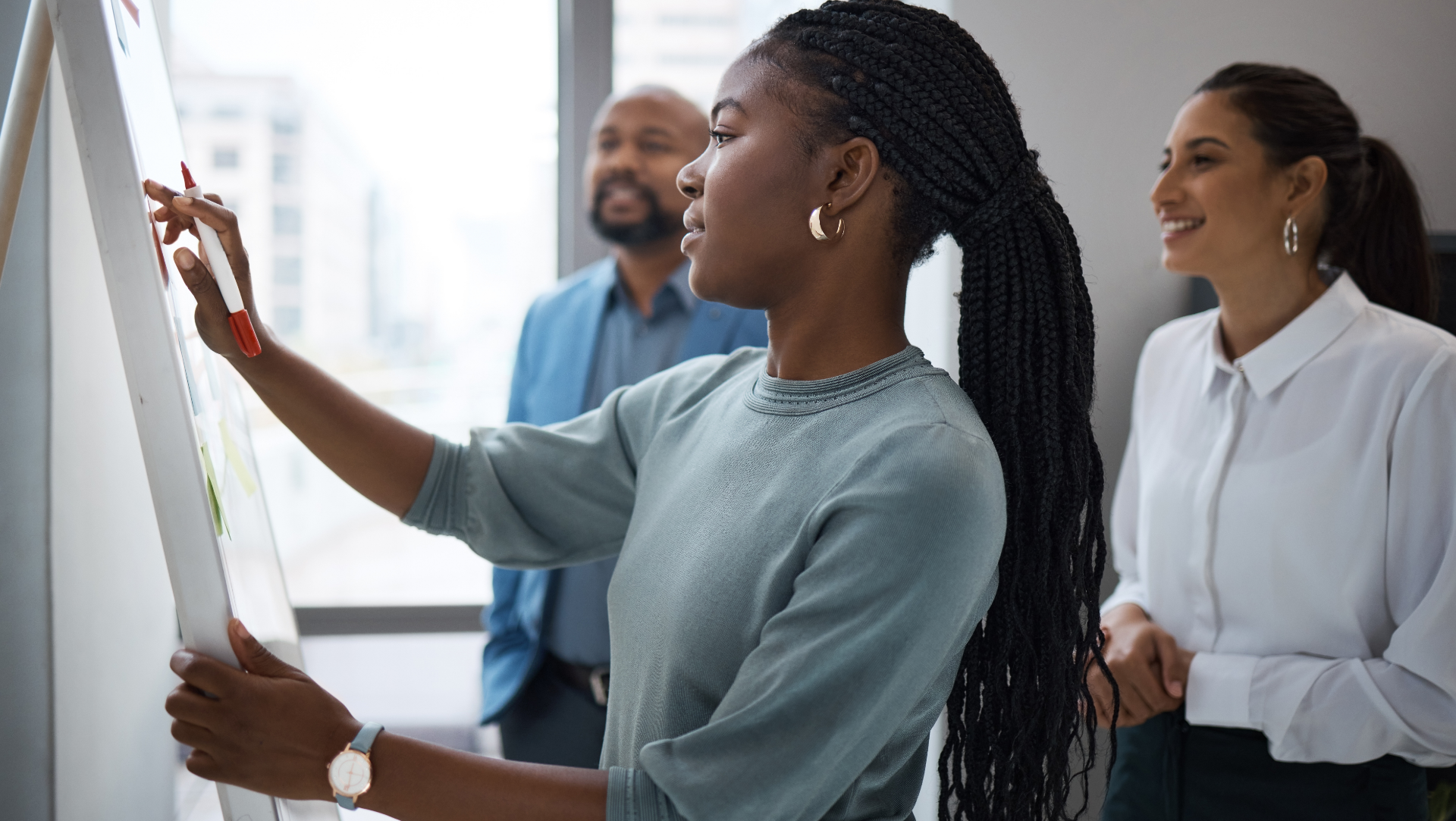 woman at whiteboard with colleagues