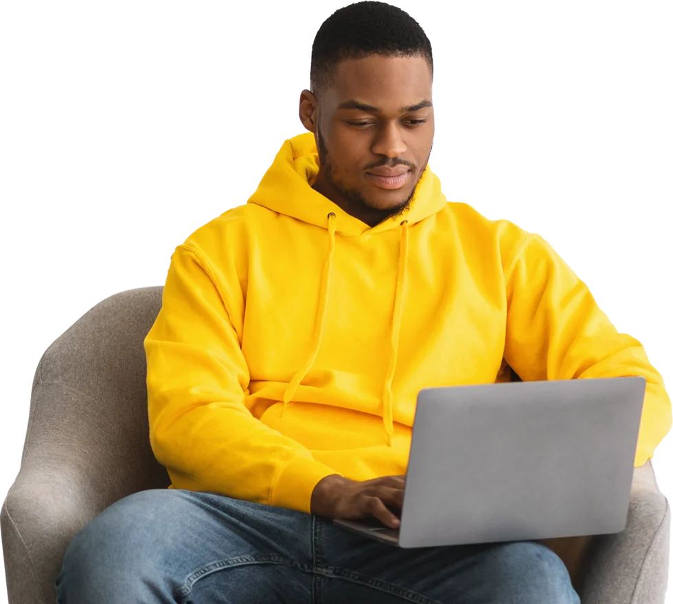 a man sits in a chair at a laptop and sends an email